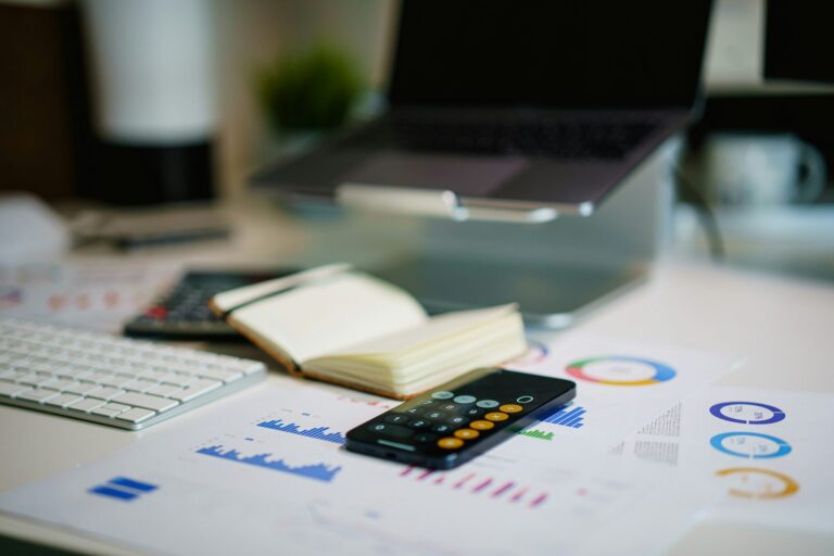 Persona calculando su presupuesto con calculadora y celular