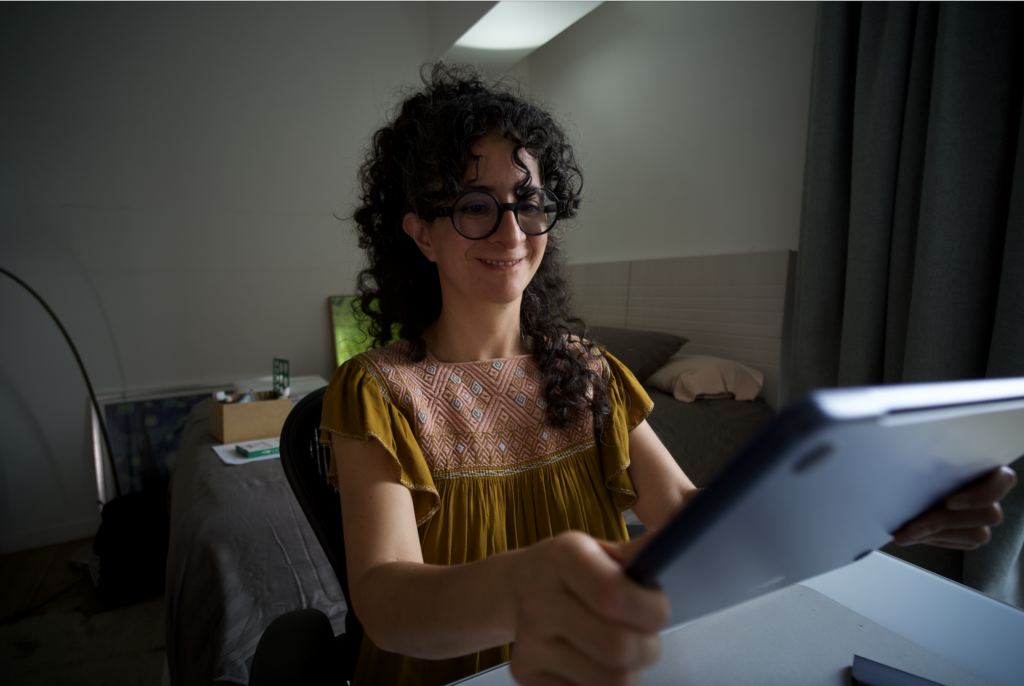 Woman smiling at a screen